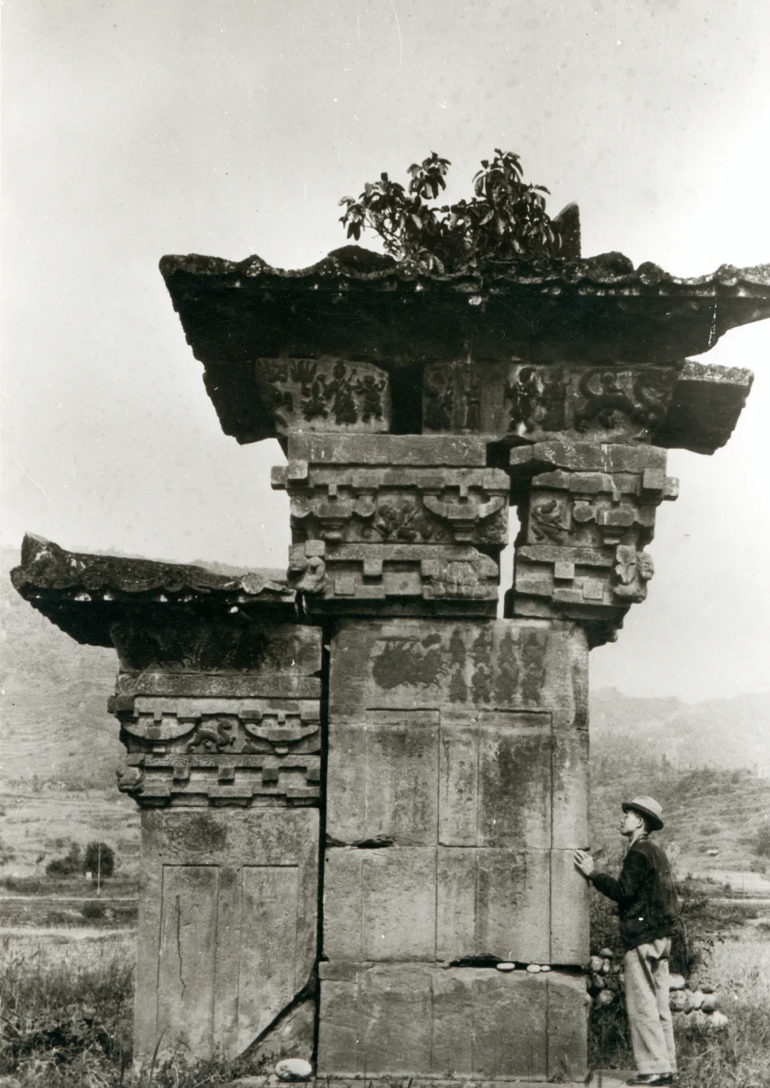 A photo taken in 1939 showing Liang Sicheng surveying Gaoyi Que, a stone-carved pillar-gate, in Sichuan province..png